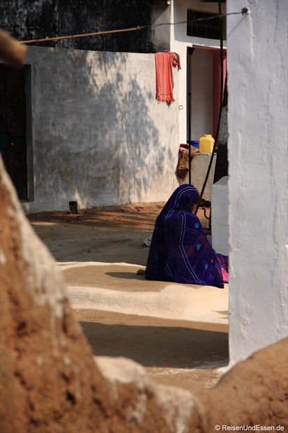 Alte Frau in einem Innenhof in Khajuraho