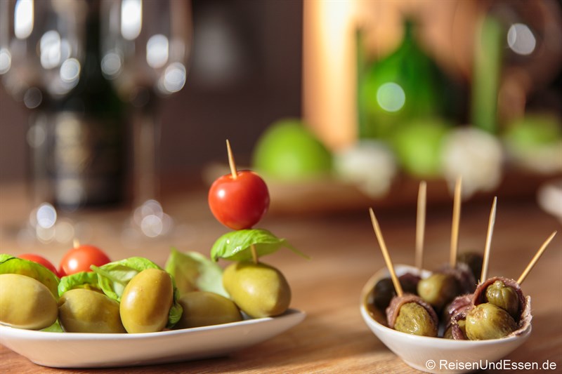 Oliven (links) und Gewürzgurken mit Sardellen