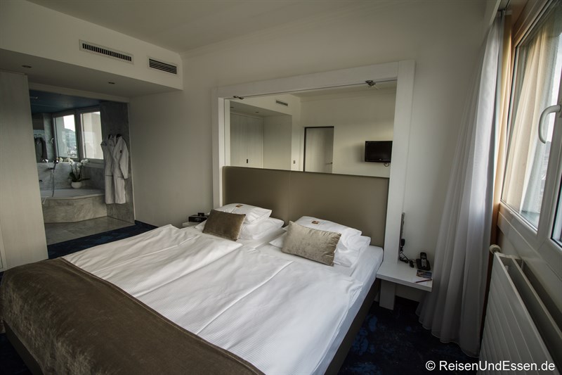 Schlafzimmer mit Verbindungstüre zum Badezimmer in der Keppler Suite im Arcotel Nike Linz