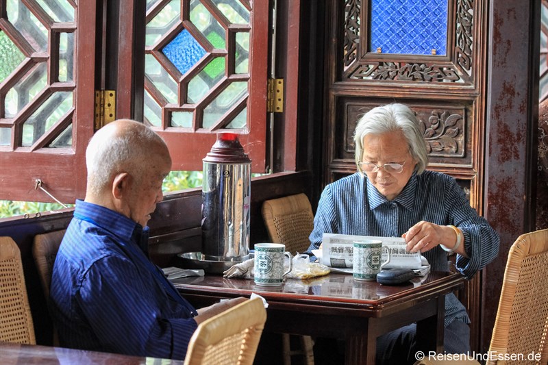 Chinesische Rentner beim Lesen und Tee