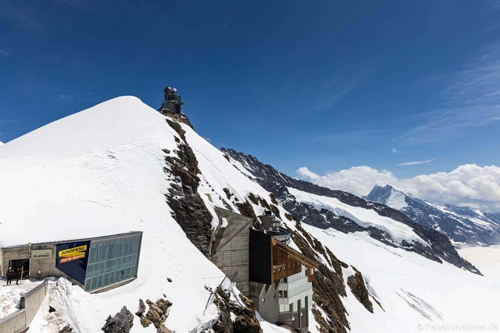 Blick vom Jungfraujoch Plateau auf Sphinx-Observatorium und Stationsgebäude